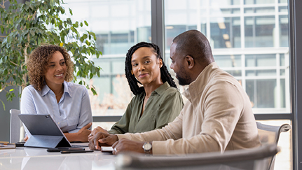 Three people sitting at a table and talking