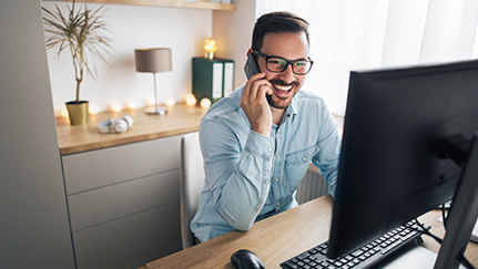man working in his home office and on the phone