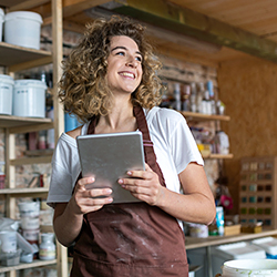 woman holding tablet inside a pottery store