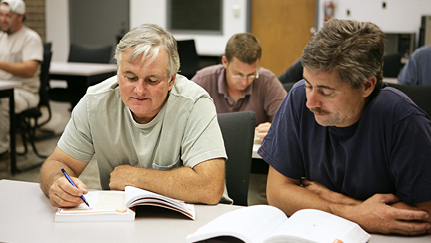 workers at a table looking at training materials