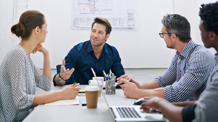 three people sitting at a table in an office