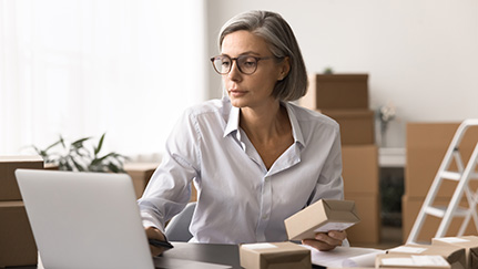 man sitting at a table looking at a laptop