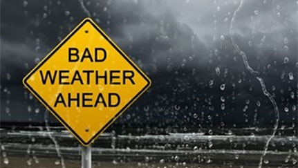 "Bad Weather Ahead" road sign with storm clouds