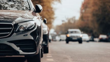 A car is parked on the side of a busy road.