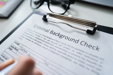 hand filling out form for a criminal background check