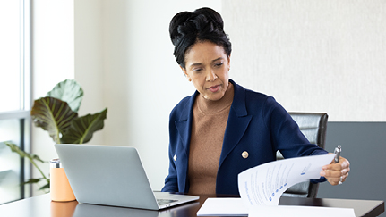 Woman at a desk, looking at documents